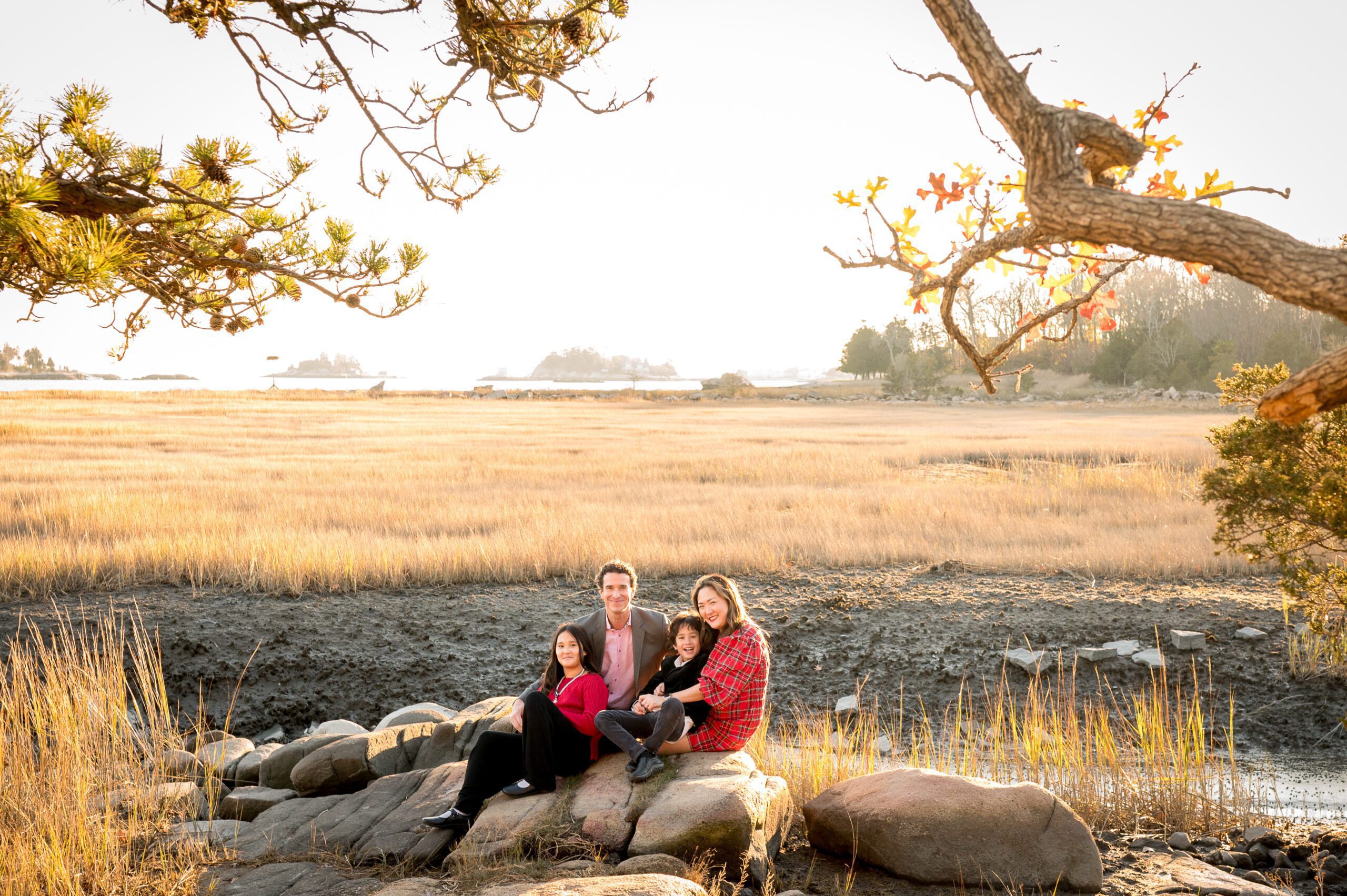 Family sitting on rock with golden light
