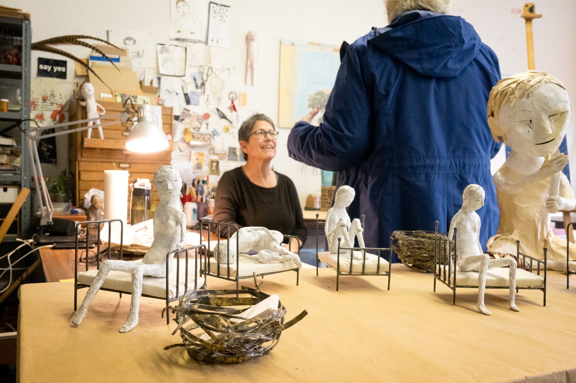 Woman with her sculptures talking with visitors
