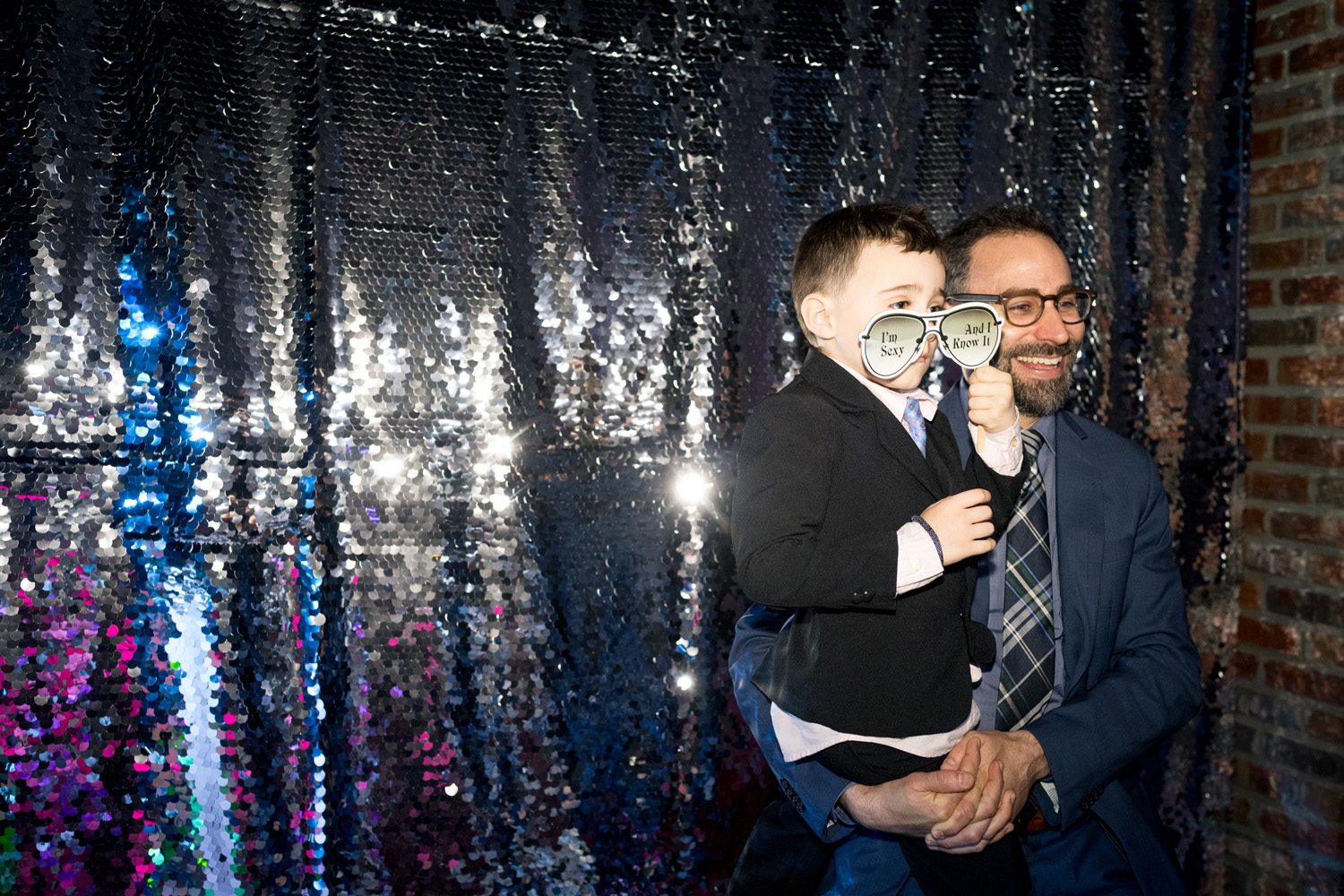 A man holding his young son for a photo booth photo