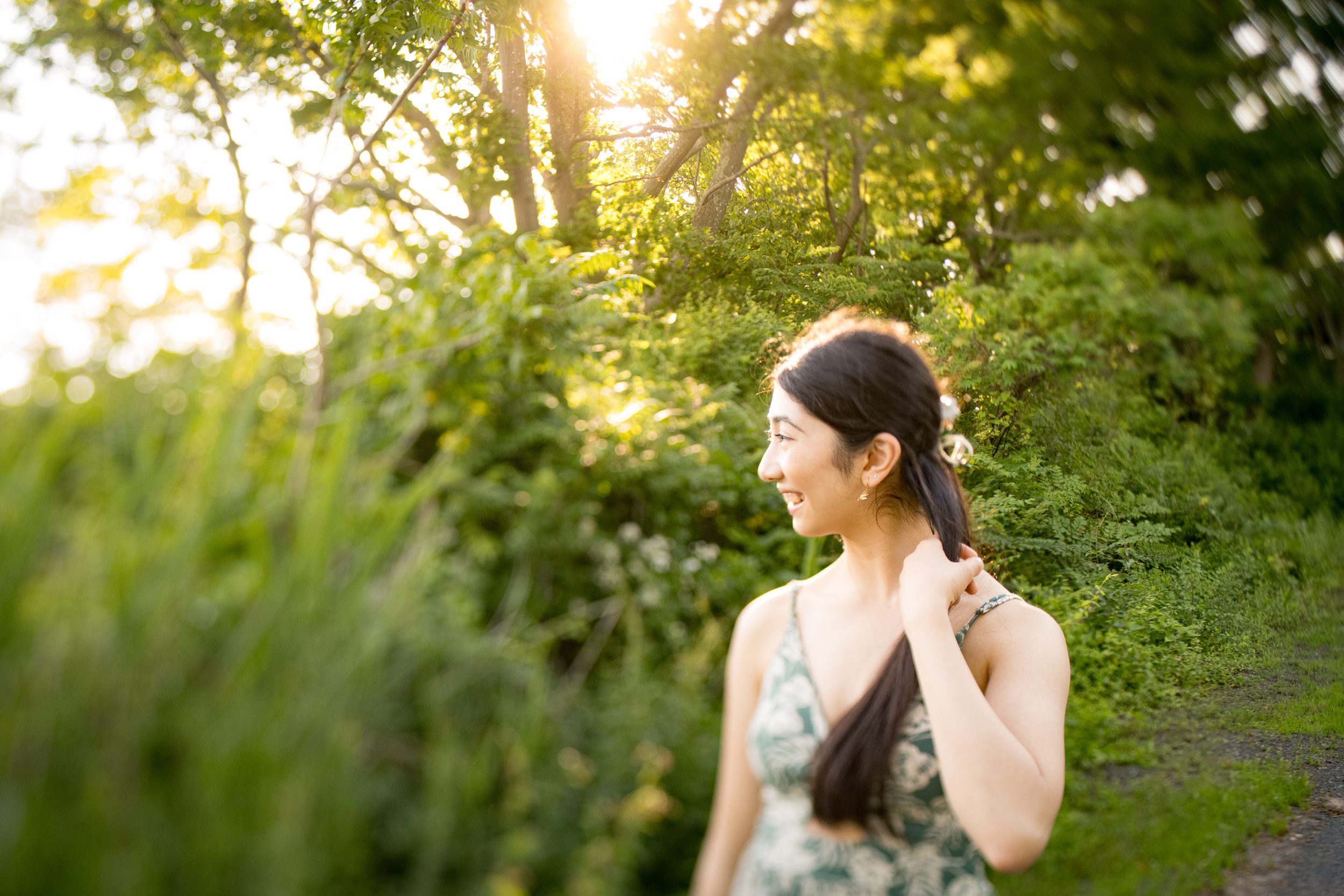 A happy graduate explores a park in the summer in a green tropical dress at sunset after finding sat prep in guilford ct