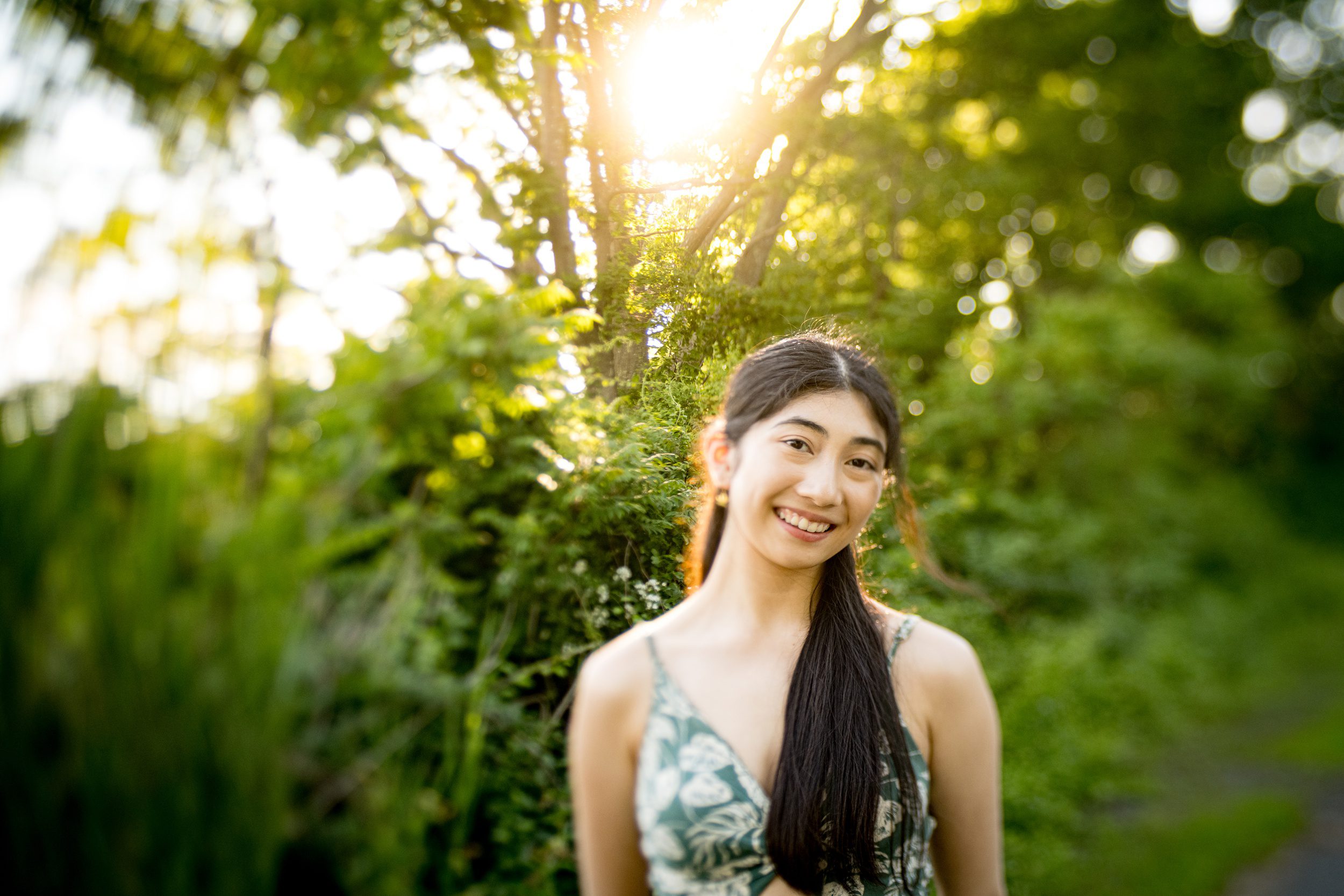 A happy high school senior in a park smiling in a green tropical dress at sunset after finding sat prep in guilford ct